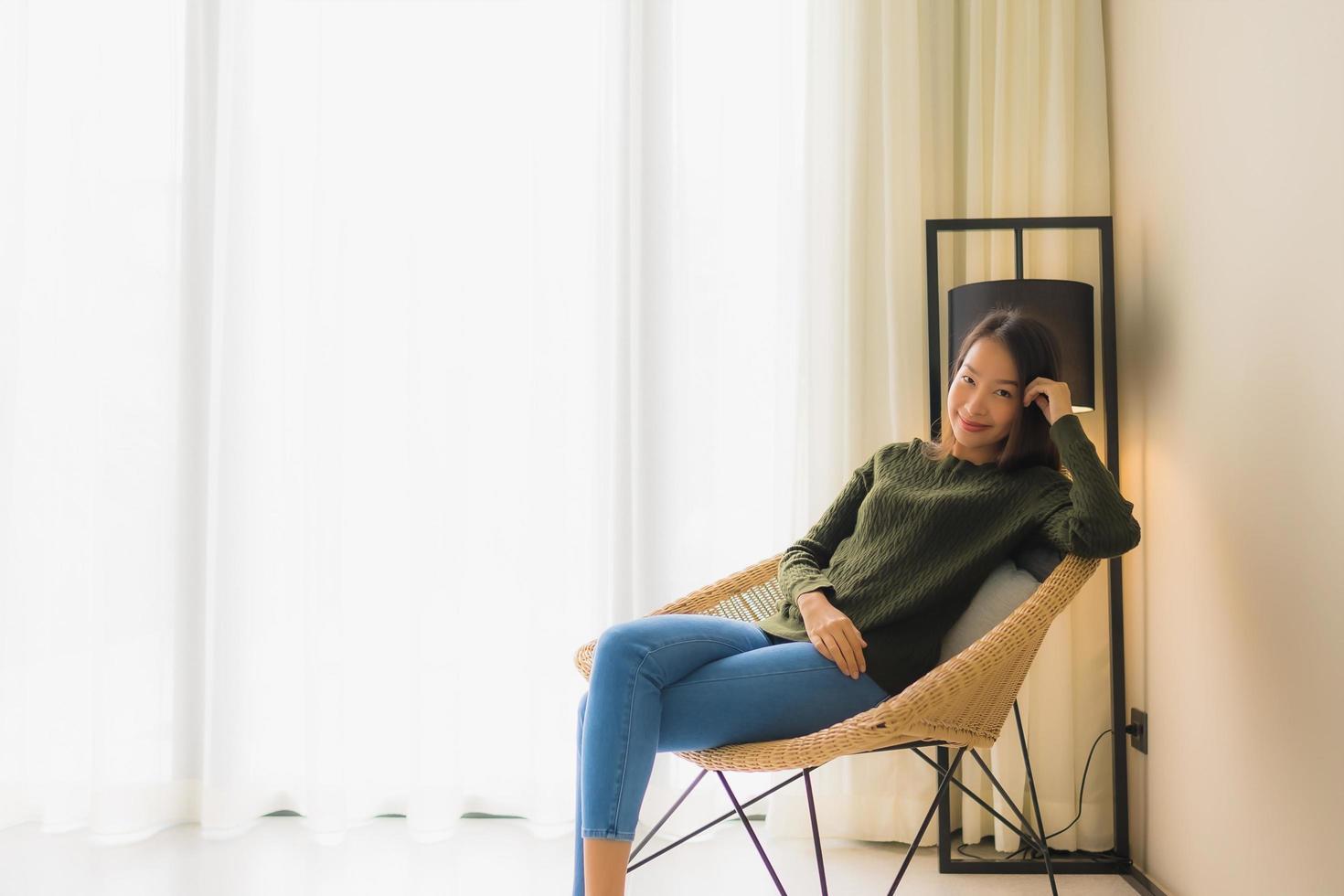 Portrait de belles jeunes femmes asiatiques sourire heureux se détendre assis sur une chaise canapé photo