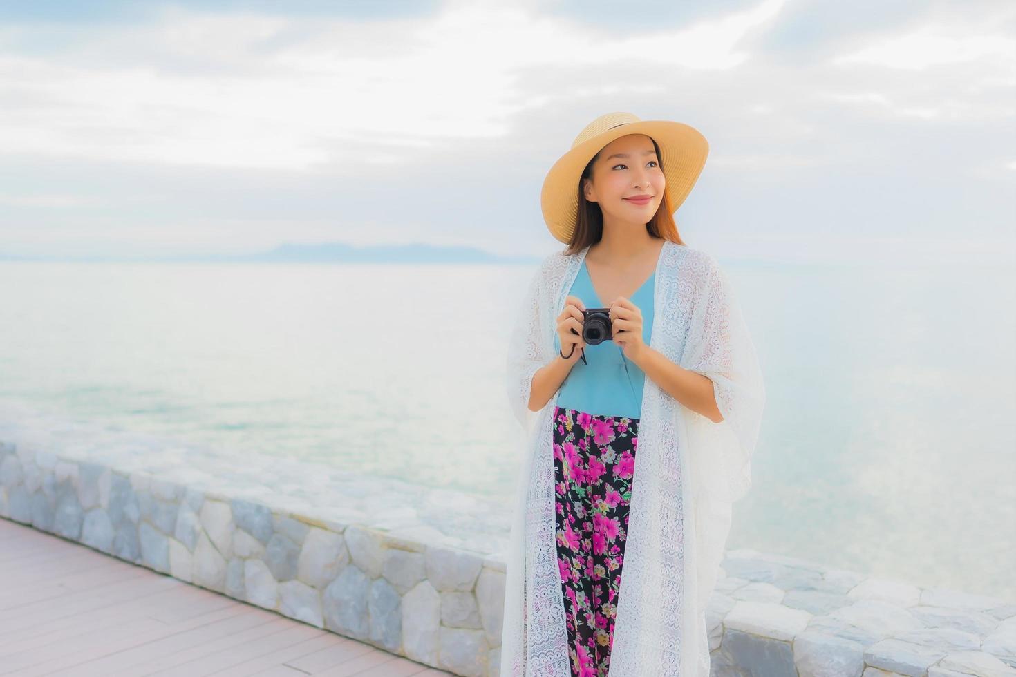 Portrait de belles jeunes femmes asiatiques sourire heureux se détendre autour de la mer plage océan photo