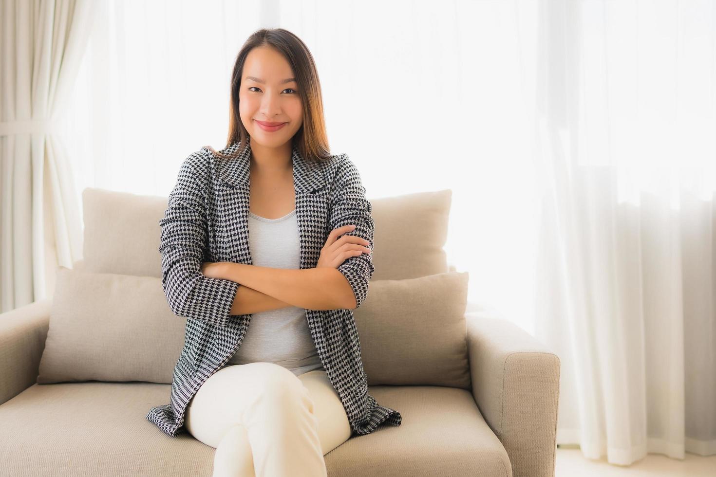 Portrait de belles jeunes femmes asiatiques sourire heureux se détendre assis sur une chaise canapé photo