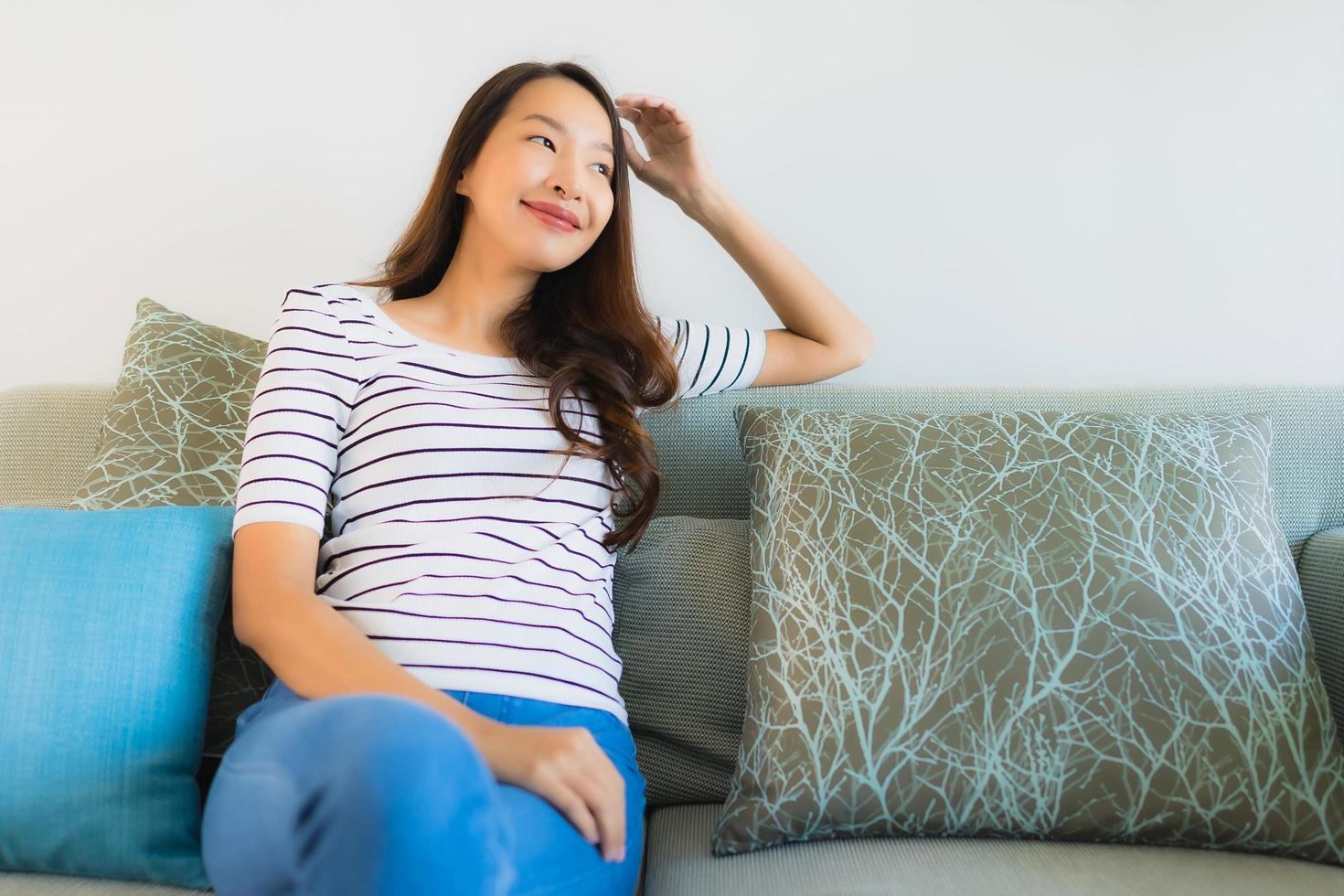 Portrait belle jeune femme asiatique sourire heureux sur canapé photo