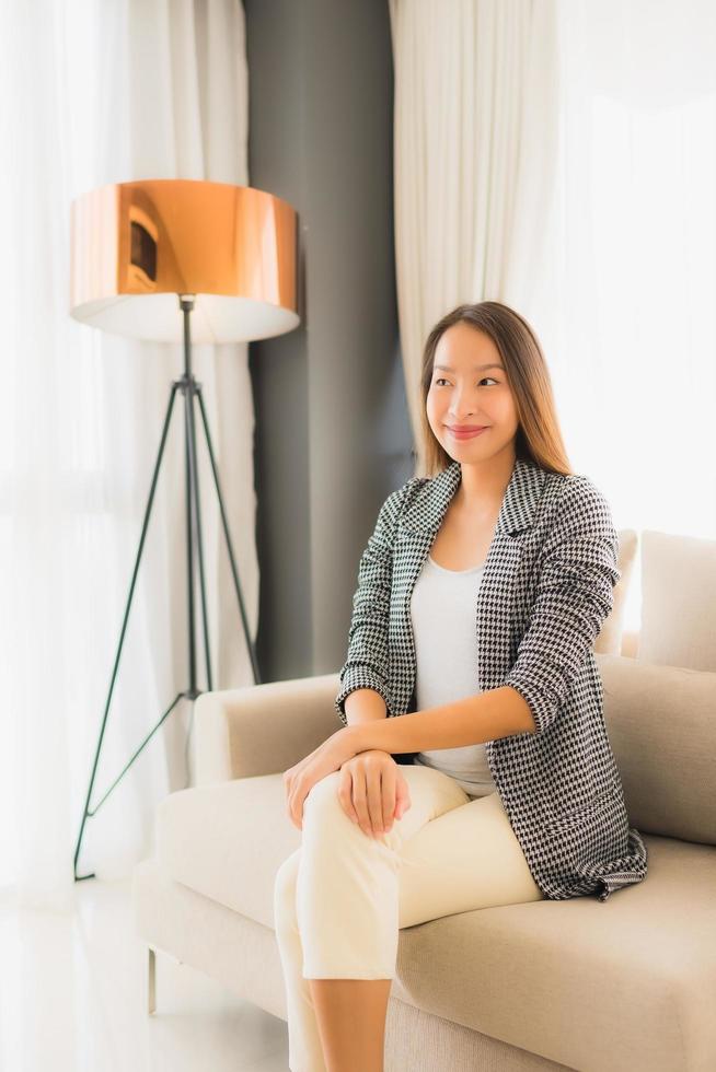 Portrait de belles jeunes femmes asiatiques sourire heureux se détendre assis sur une chaise canapé photo