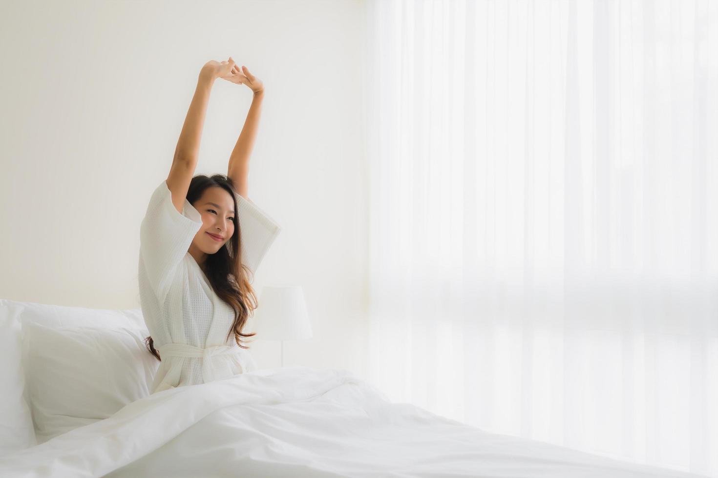 Portrait de belles jeunes femmes asiatiques sourire heureux sur le lit photo