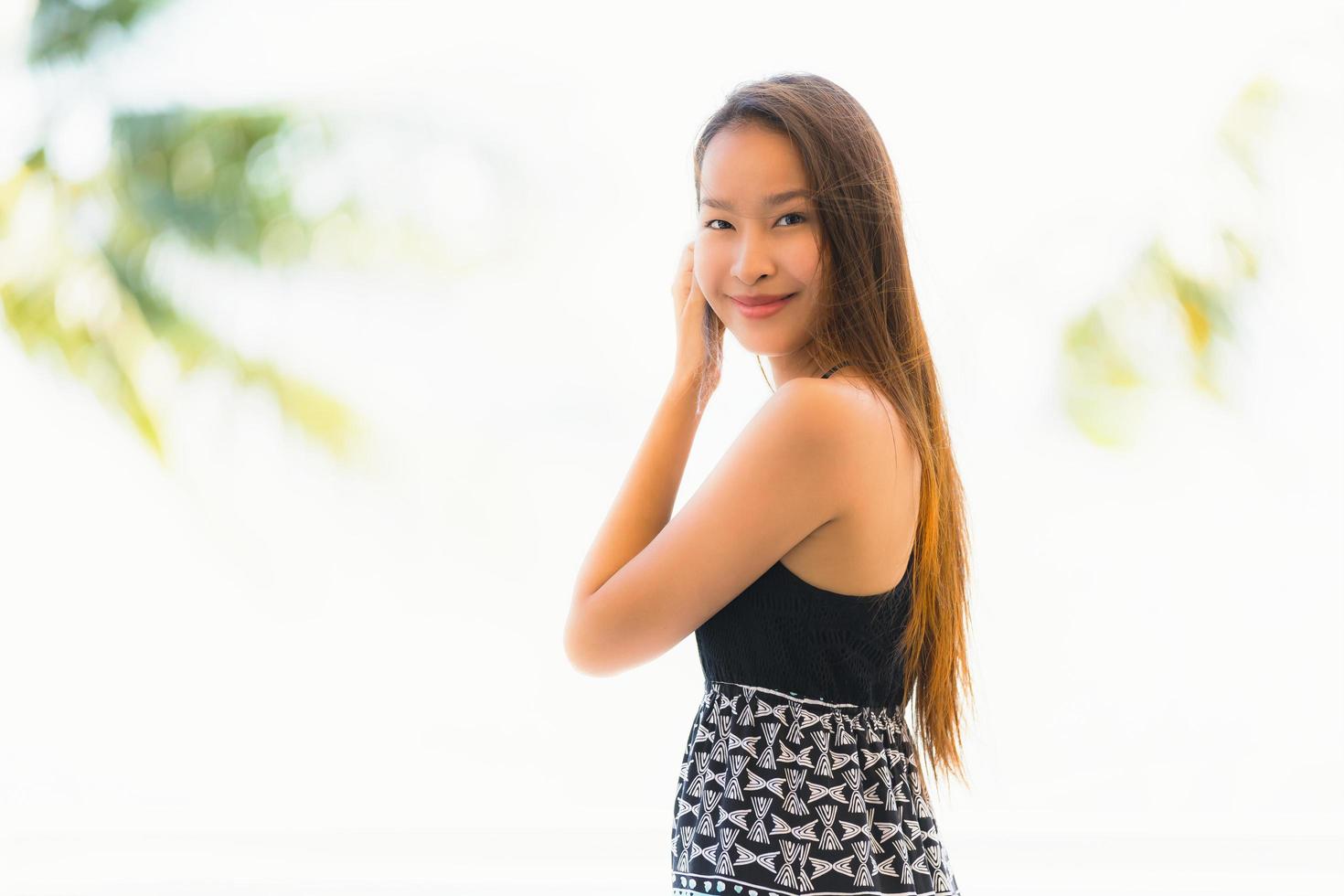 Portrait belle jeune femme asiatique heureuse et souriante avec voyage dans un complexe hôtelier près de la mer et de la plage photo