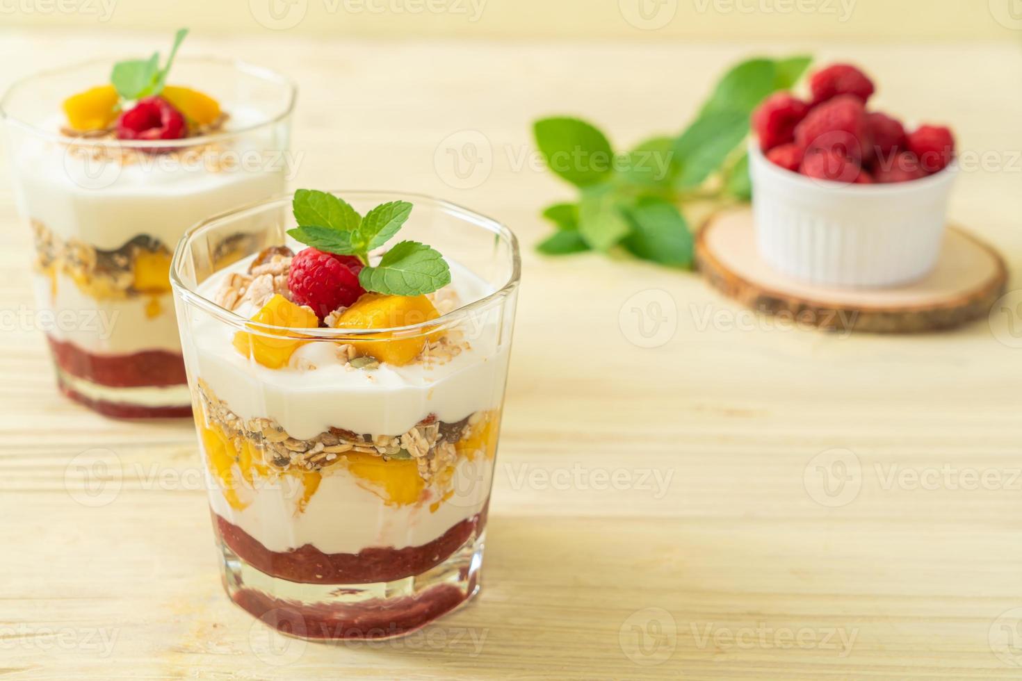 mangue fraîche faite maison et framboise fraîche avec yaourt et granola - style alimentaire sain photo