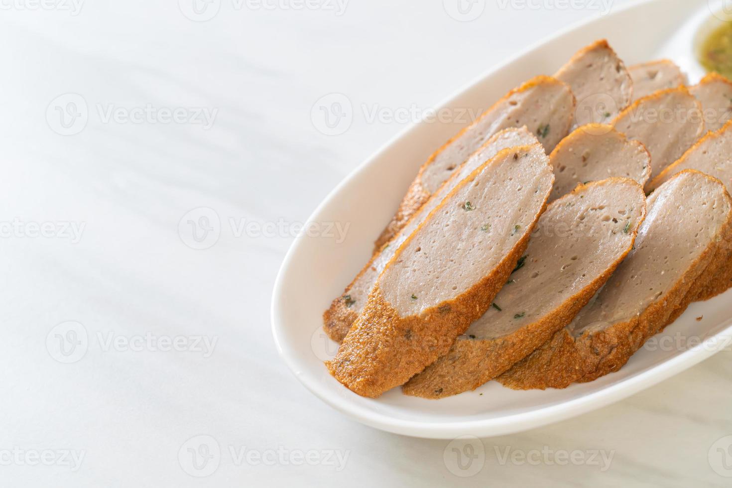 gâteau de poisson chinois frit ou ligne de boule de poisson tranché avec une sauce aux fruits de mer épicée photo