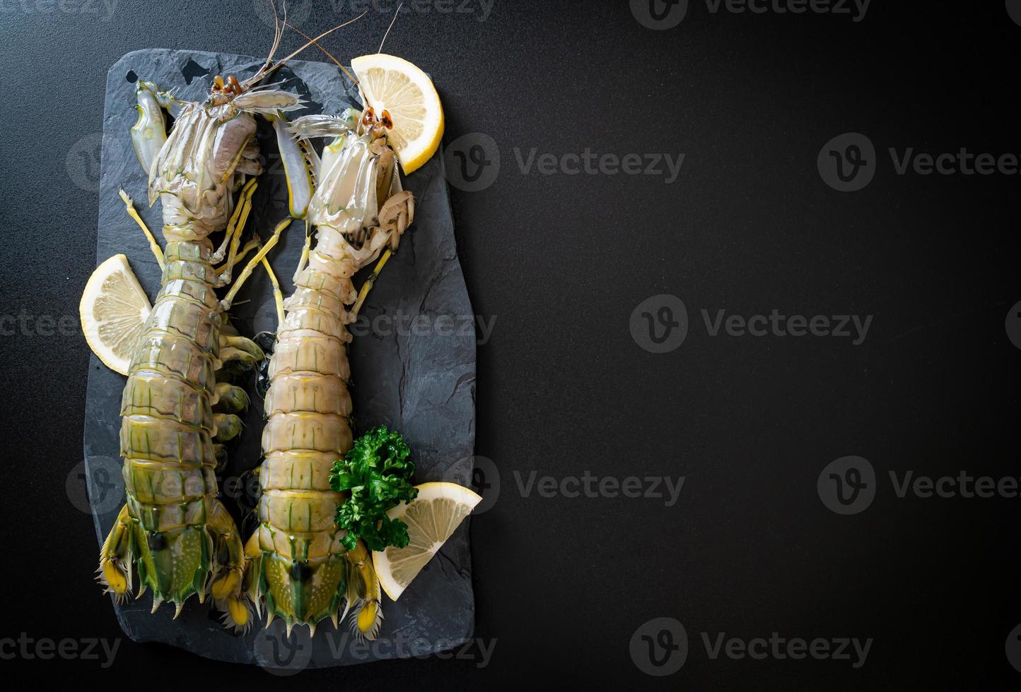 Crevettes mantis fraîches au citron sur une planche photo