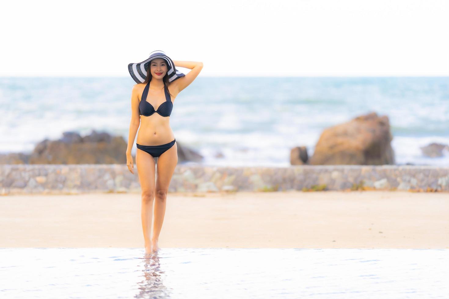 Portrait belle jeune femme asiatique porter un bikini autour de la piscine de l'hôtel resort près de la mer océan plage photo