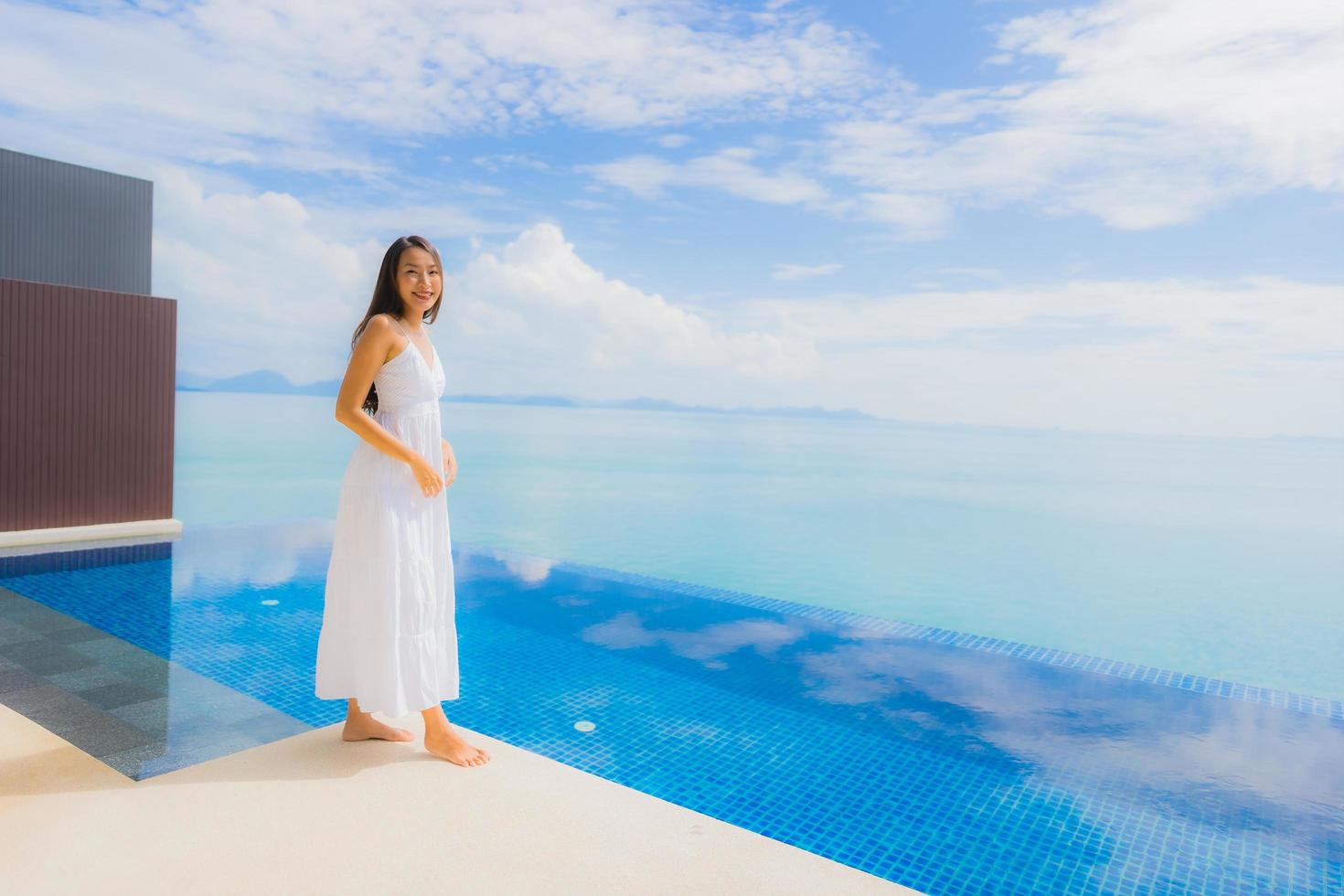 Portrait jeune femme asiatique se détendre sourire heureux autour de la piscine de l'hôtel et du complexe photo