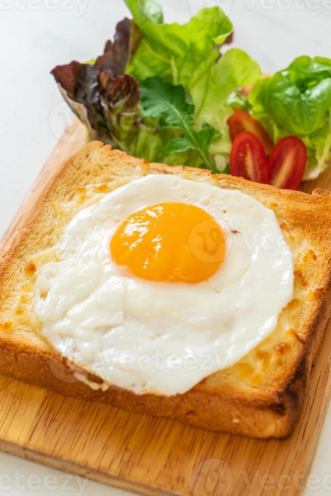 pain maison grillé avec du fromage et un œuf au plat sur le dessus avec une salade de légumes pour le petit-déjeuner photo