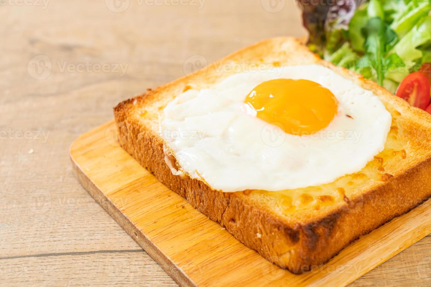 pain maison grillé avec du fromage et un œuf au plat sur le dessus avec une salade de légumes pour le petit-déjeuner photo