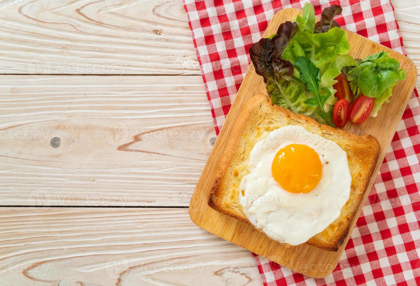 pain maison grillé avec du fromage et un œuf au plat sur le dessus avec une salade de légumes pour le petit-déjeuner photo