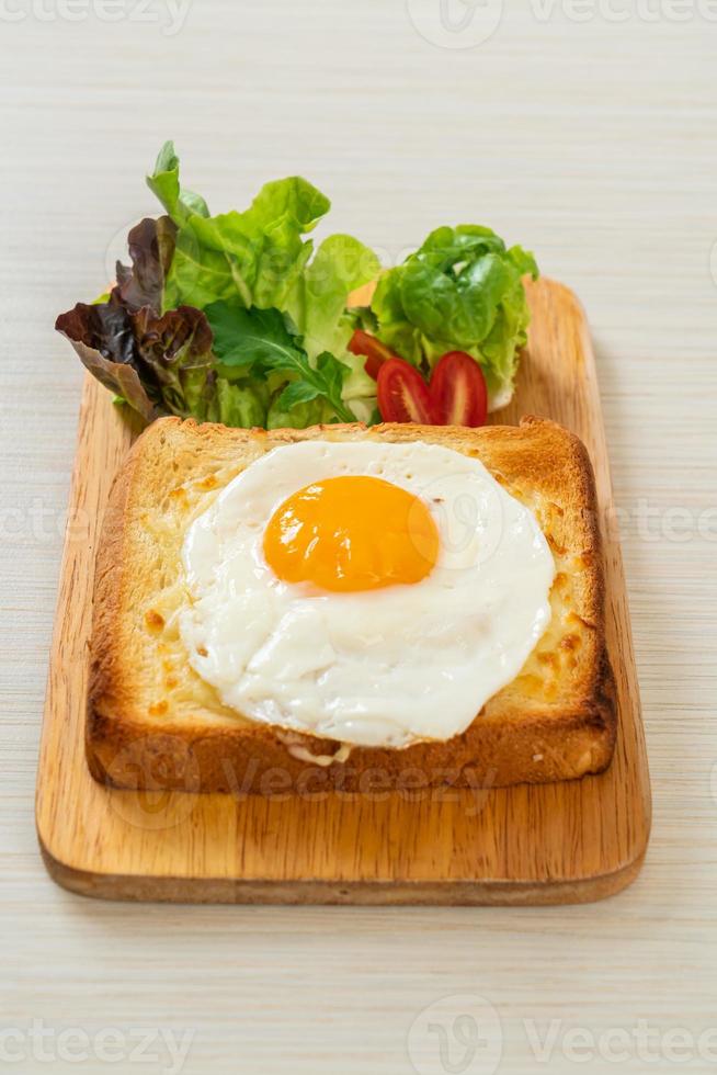 pain maison grillé avec du fromage et un œuf au plat sur le dessus avec une salade de légumes pour le petit-déjeuner photo