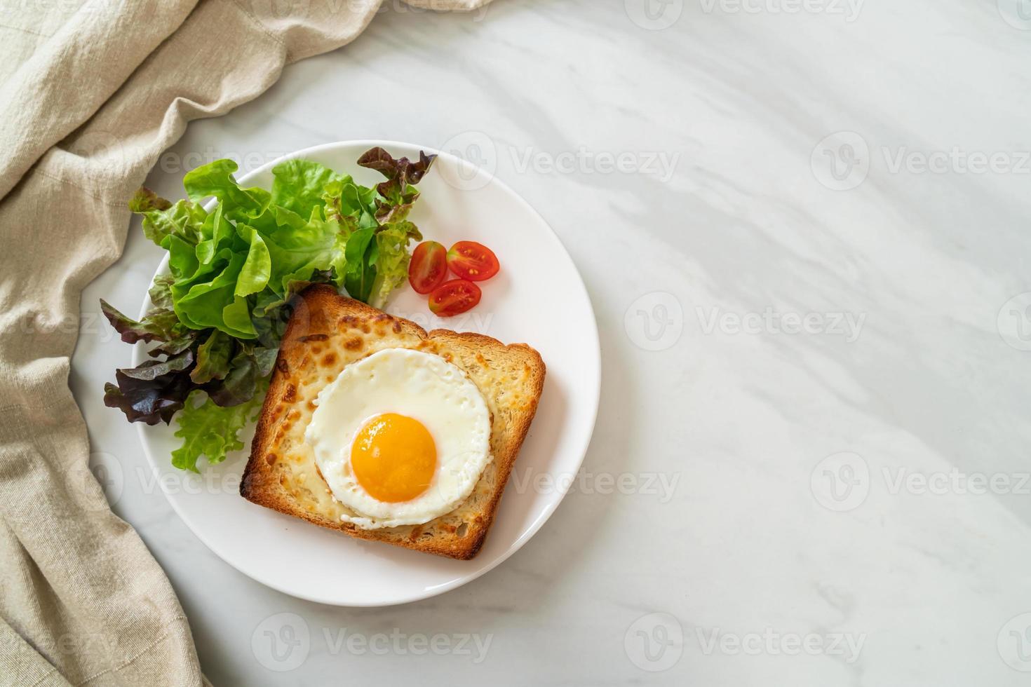 pain maison grillé avec du fromage et un œuf au plat sur le dessus avec une salade de légumes pour le petit-déjeuner photo