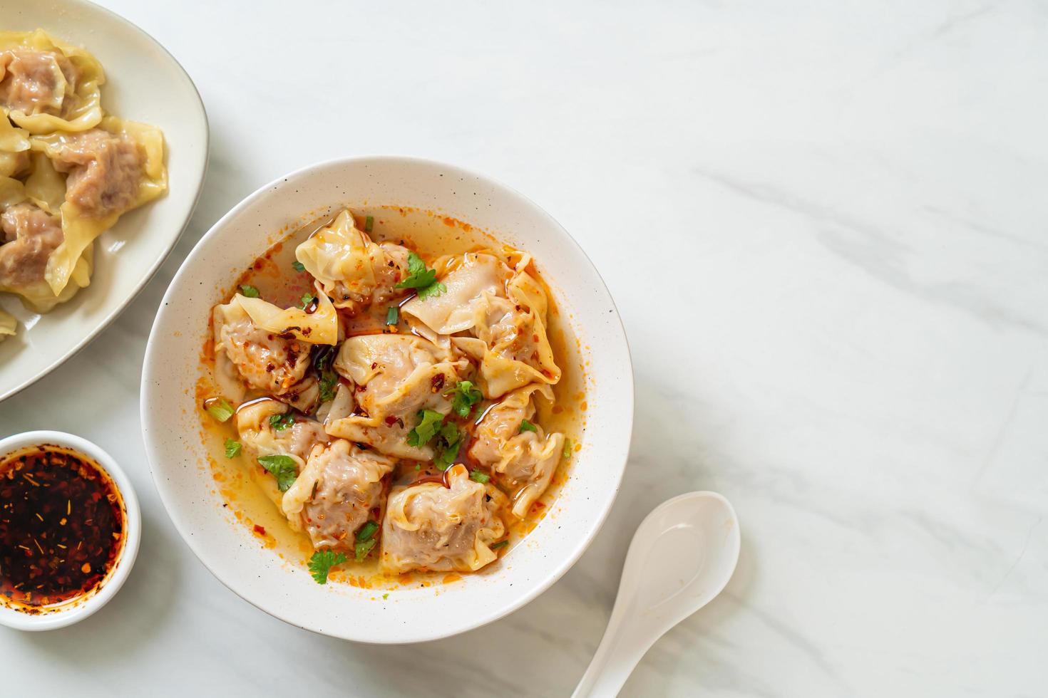 soupe wonton de porc ou soupe de boulettes de porc avec chili rôti - style cuisine asiatique photo