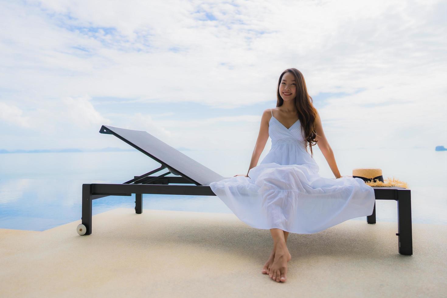 Portrait jeune femme asiatique se détendre sourire heureux autour de la piscine de l'hôtel et du complexe photo