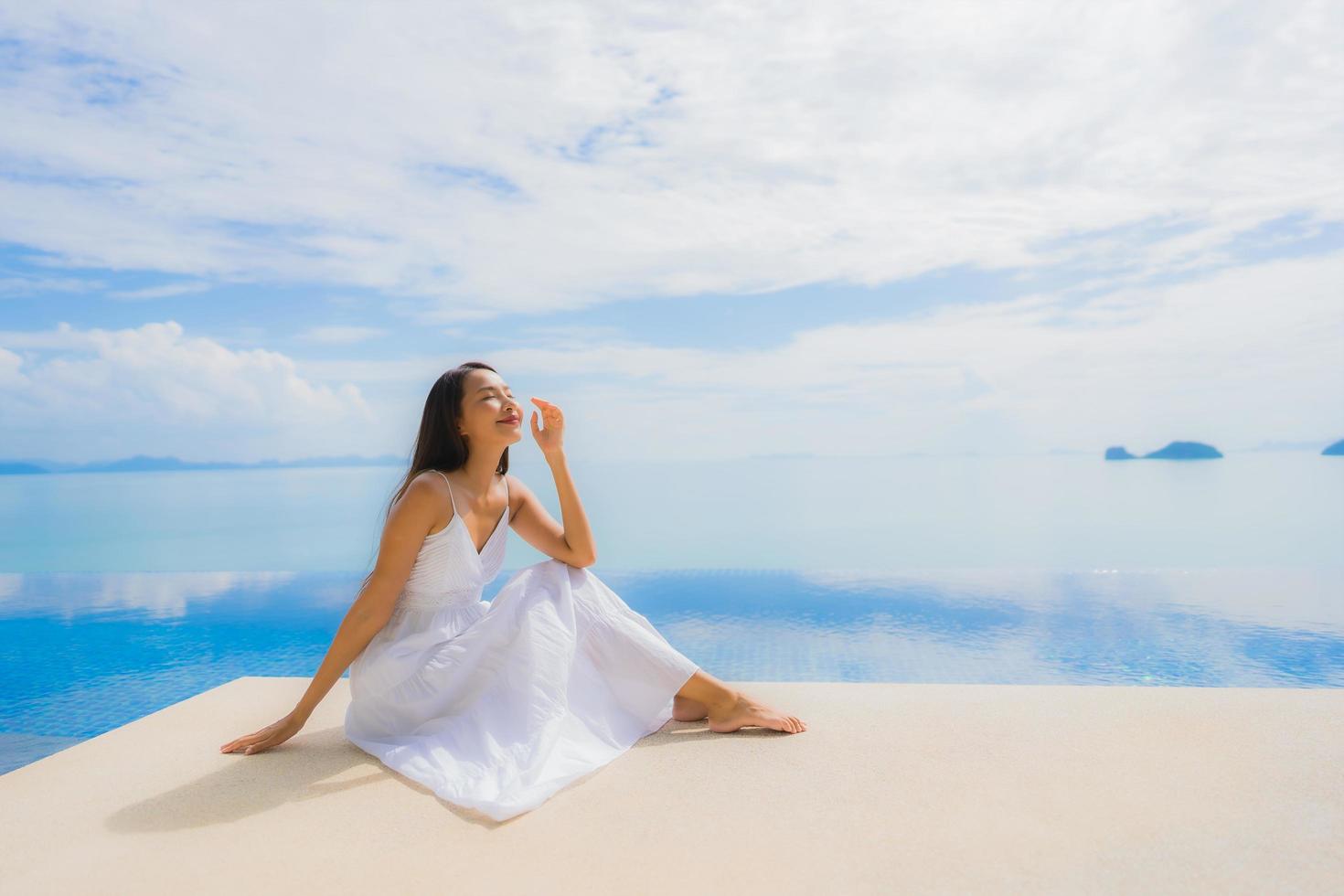 Portrait jeune femme asiatique se détendre sourire heureux autour de la piscine de l'hôtel et du complexe photo