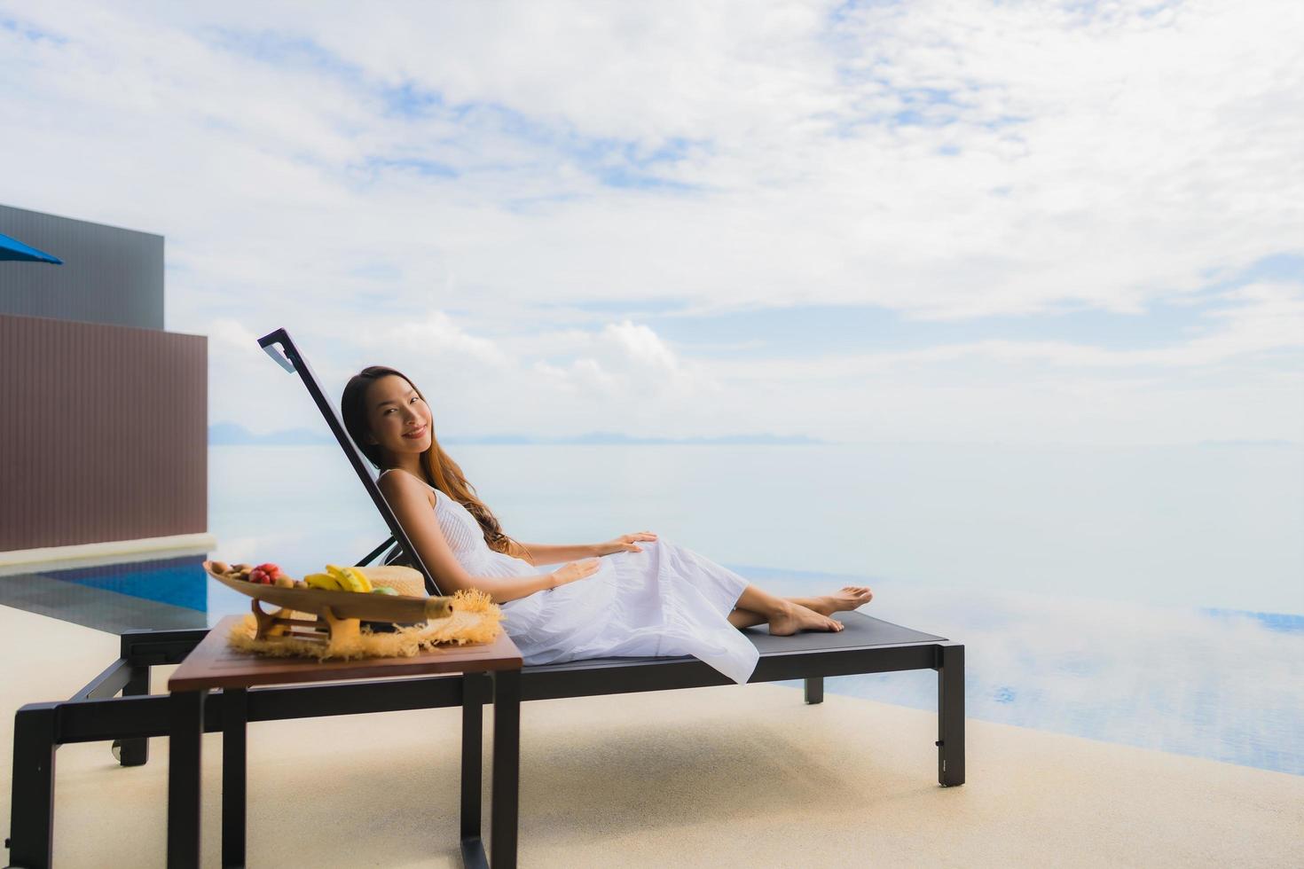 Portrait jeune femme asiatique se détendre sourire heureux autour de la piscine de l'hôtel et du complexe photo