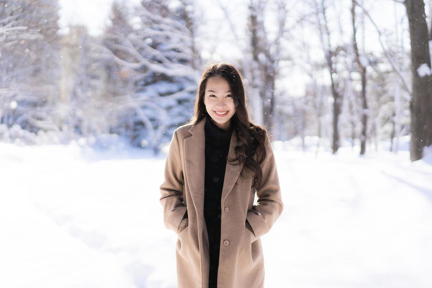 portrait jeune belle femme asiatique sourire joyeux voyage et profiter de la neige hiver photo