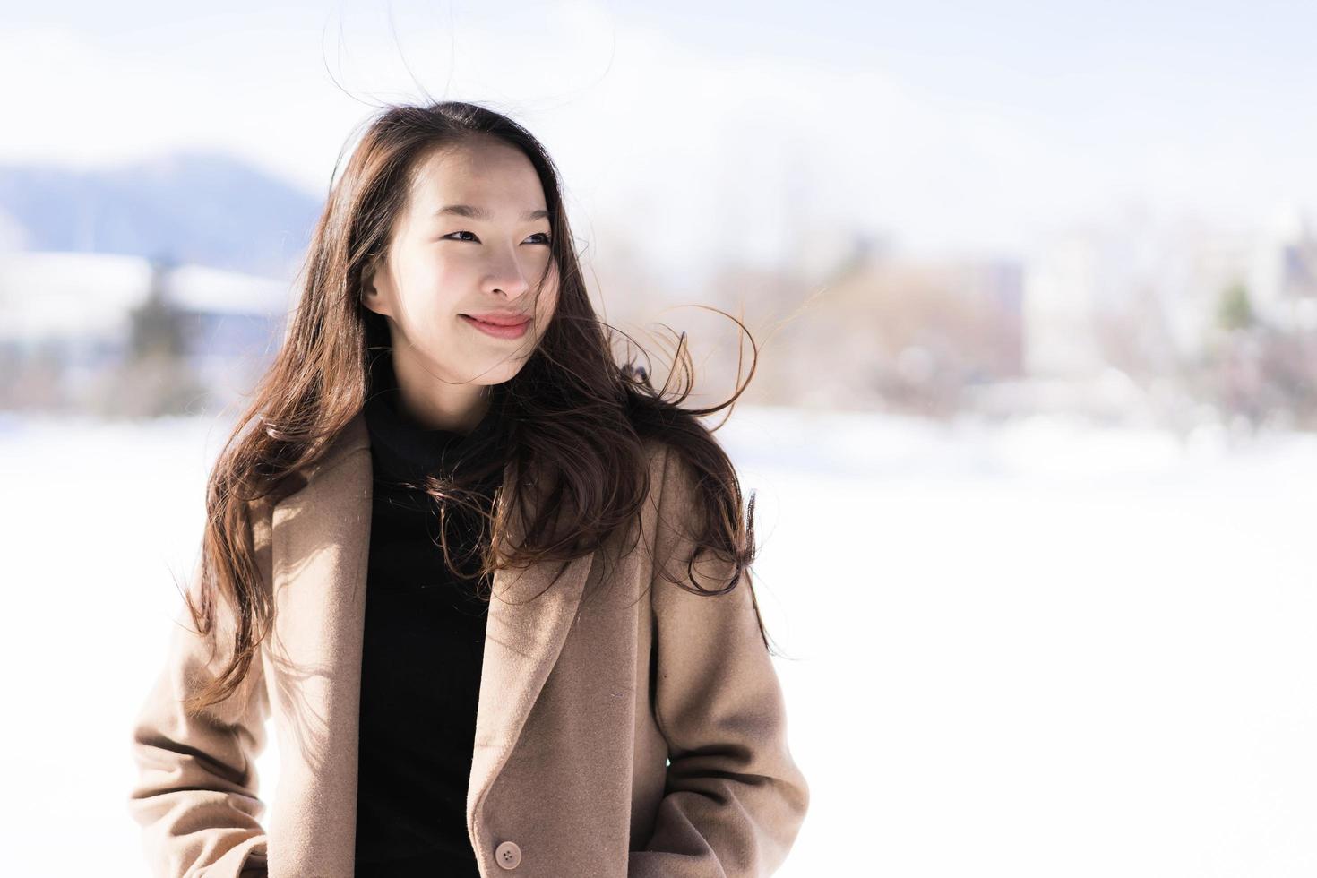 portrait jeune belle femme asiatique sourire joyeux voyage et profiter de la neige hiver photo