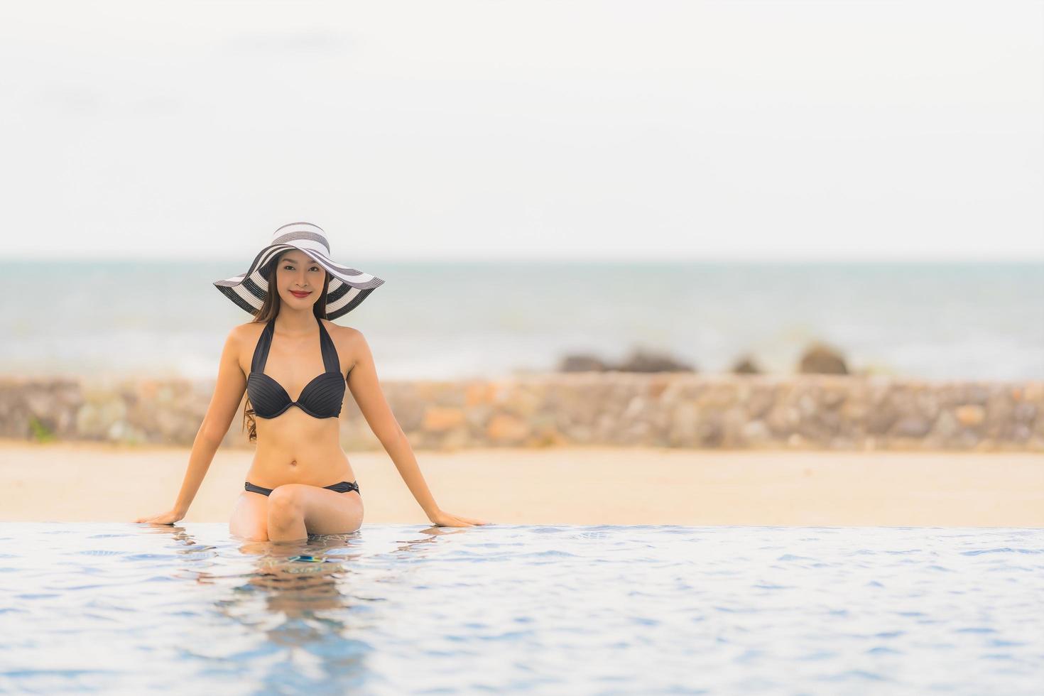 Portrait belle jeune femme asiatique porter un bikini autour de la piscine de l'hôtel resort près de la mer océan plage photo