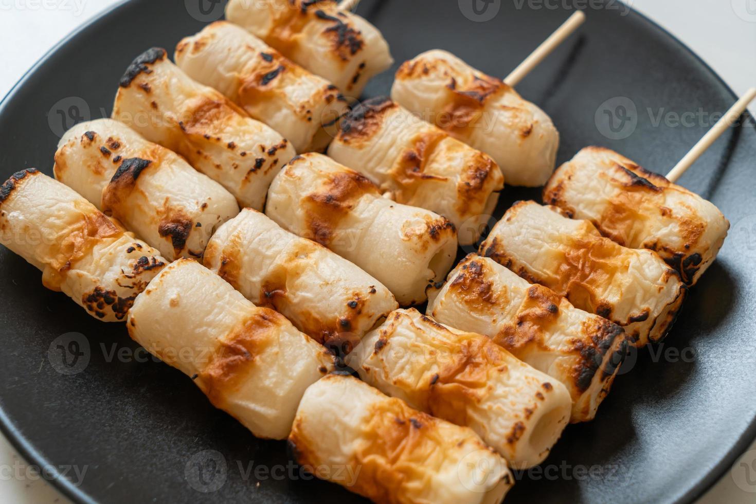 Gâteau de pâte de poisson en forme de tube grillé ou brochette de calmar en tube sur plaque photo