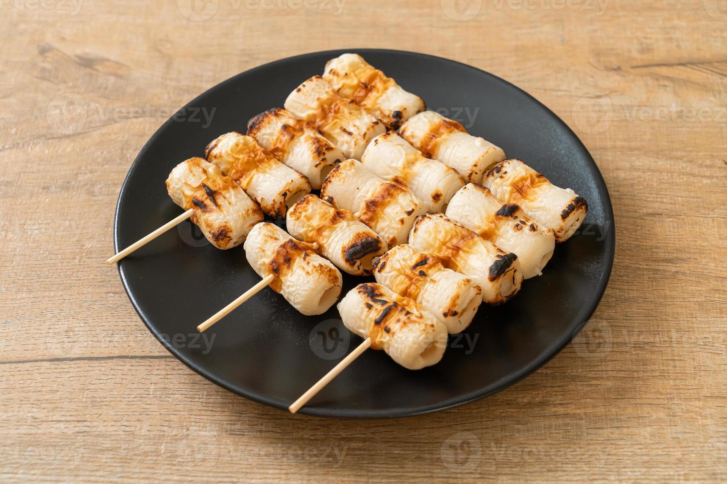 Gâteau de pâte de poisson en forme de tube grillé ou brochette de calmar en tube sur plaque photo