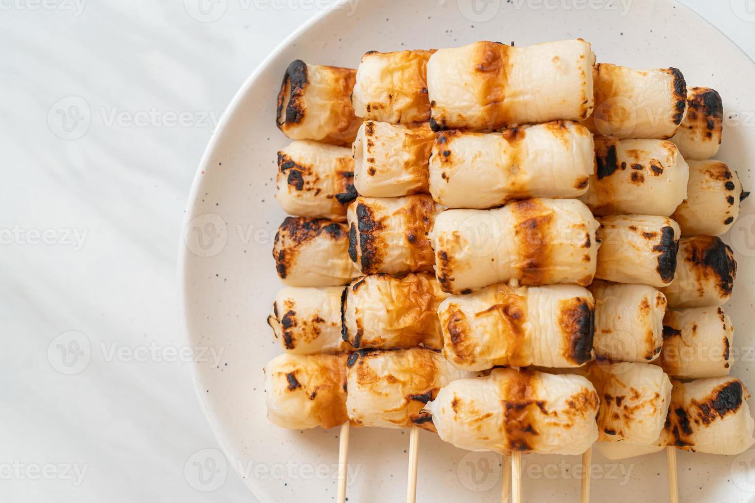 Gâteau de pâte de poisson en forme de tube grillé ou brochette de calmar en tube sur plaque photo