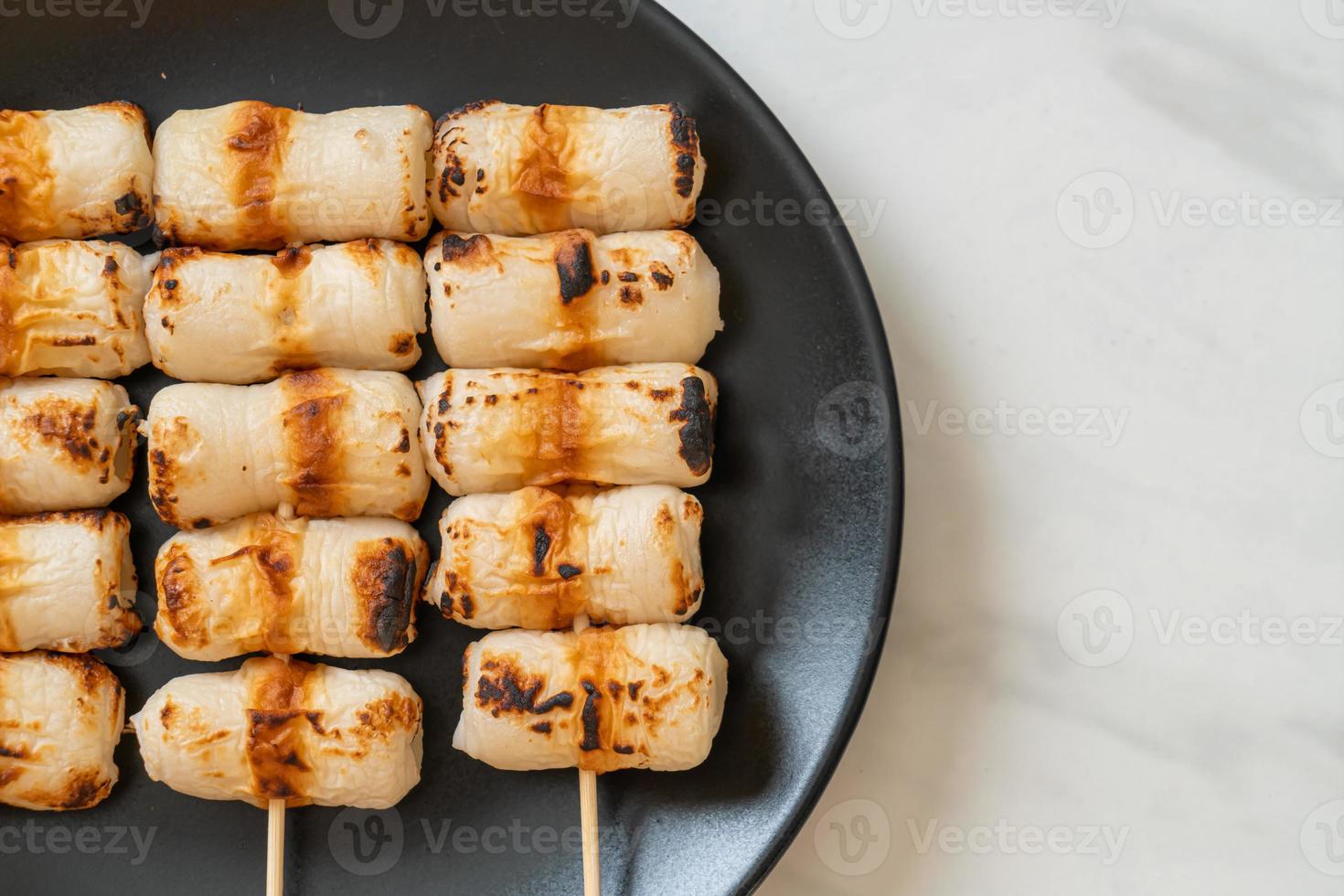 Gâteau de pâte de poisson en forme de tube grillé ou brochette de calmar en tube sur plaque photo