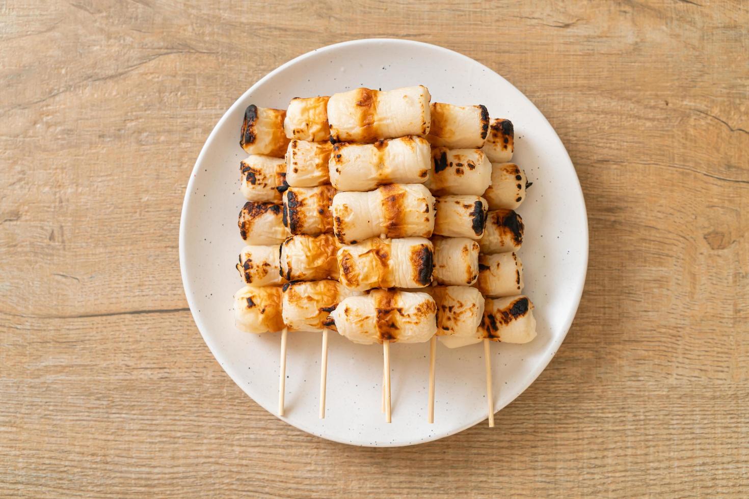 Gâteau de pâte de poisson en forme de tube grillé ou brochette de calmar en tube sur plaque photo