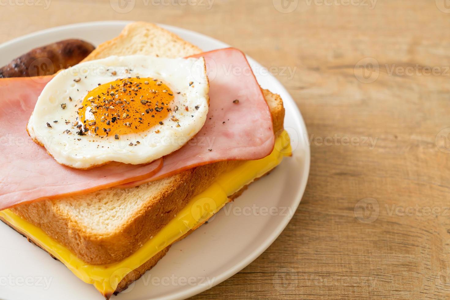 pain maison, fromage grillé, jambon garni et œuf au plat avec saucisse de porc pour le petit-déjeuner photo