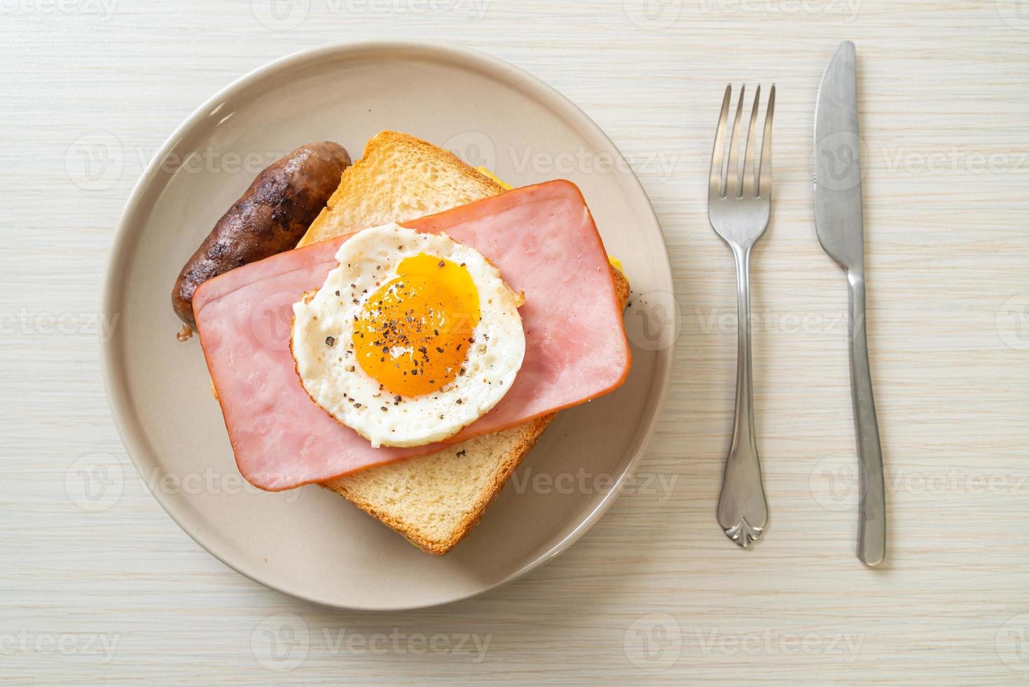 pain maison, fromage grillé, jambon garni et œuf au plat avec saucisse de porc pour le petit-déjeuner photo