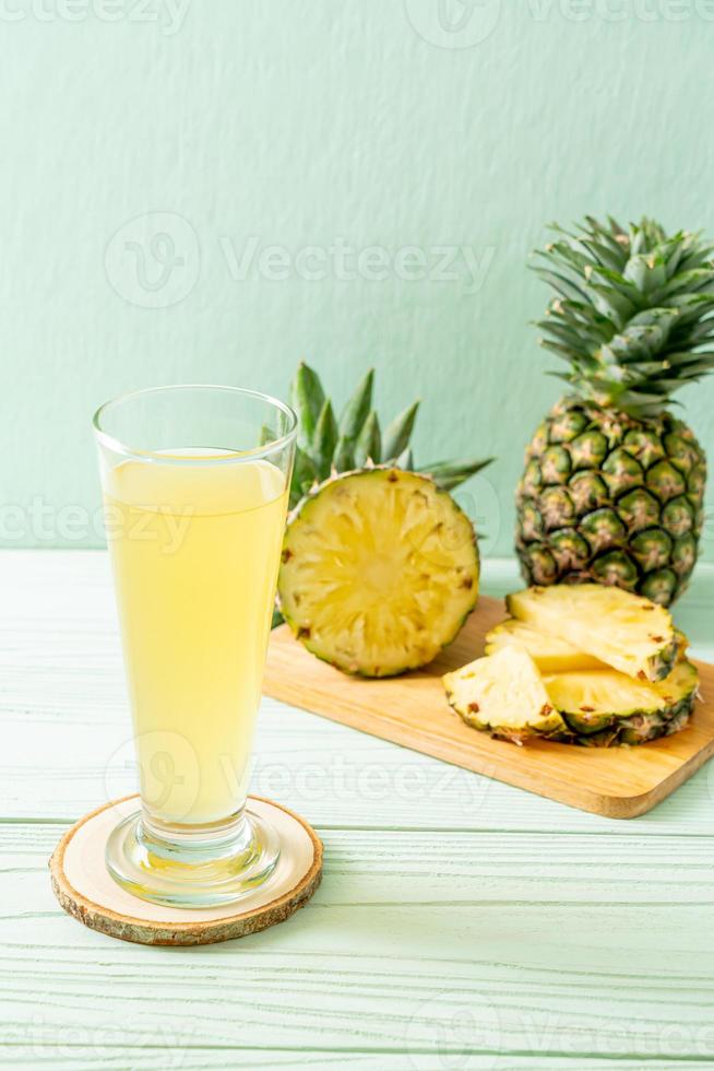 jus d'ananas frais sur fond de bois photo