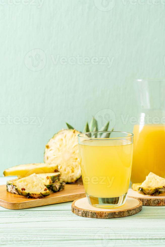 jus d'ananas frais sur fond de bois photo