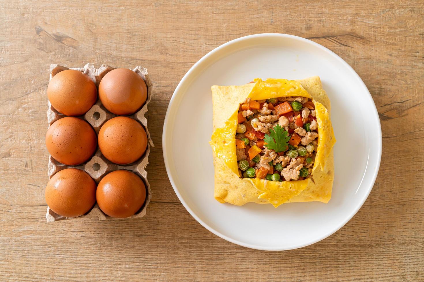 wrap aux œufs ou œuf farci avec du porc haché, des carottes, des tomates et des pois verts photo