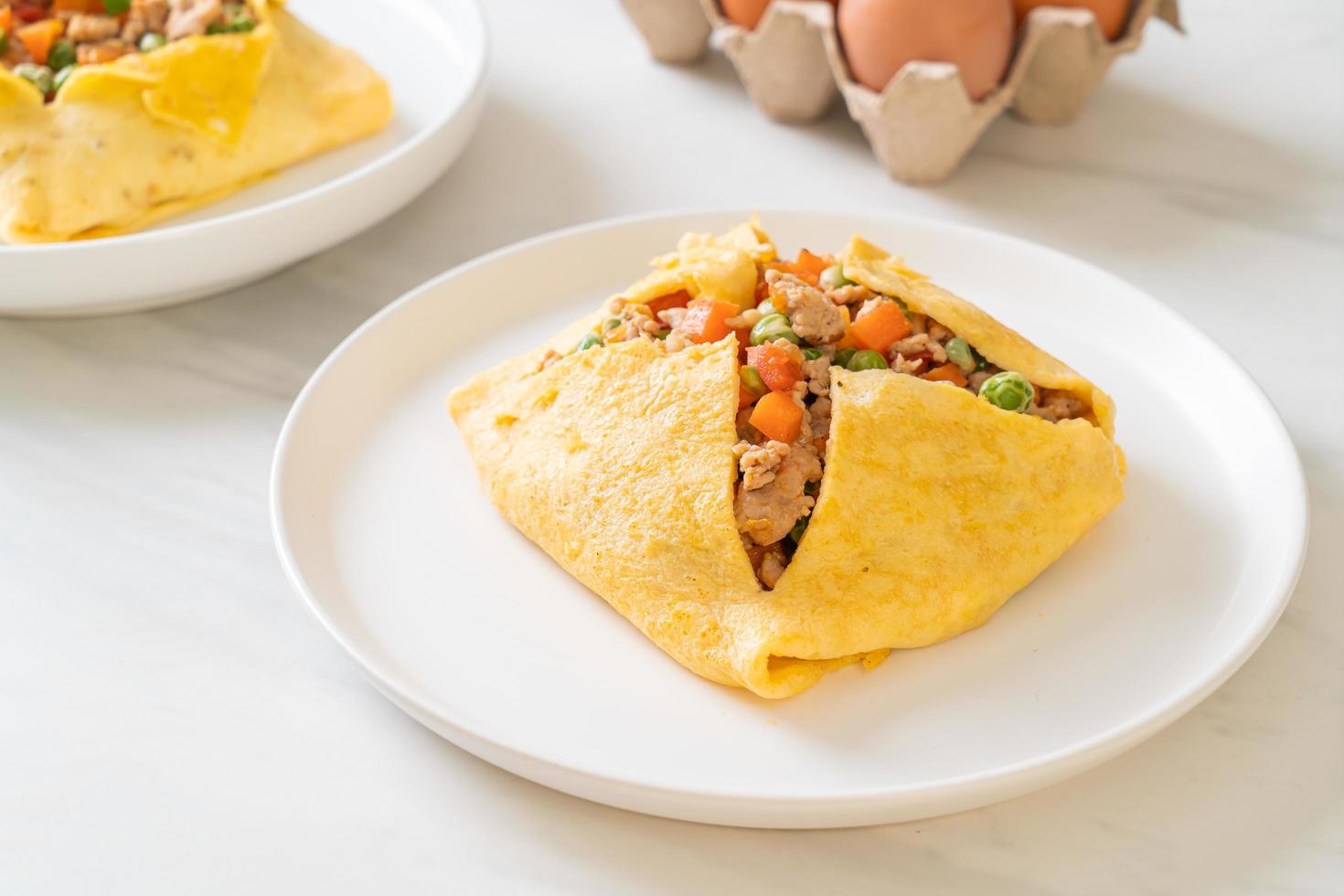 wrap aux œufs ou œuf farci avec du porc haché, des carottes, des tomates et des pois verts photo