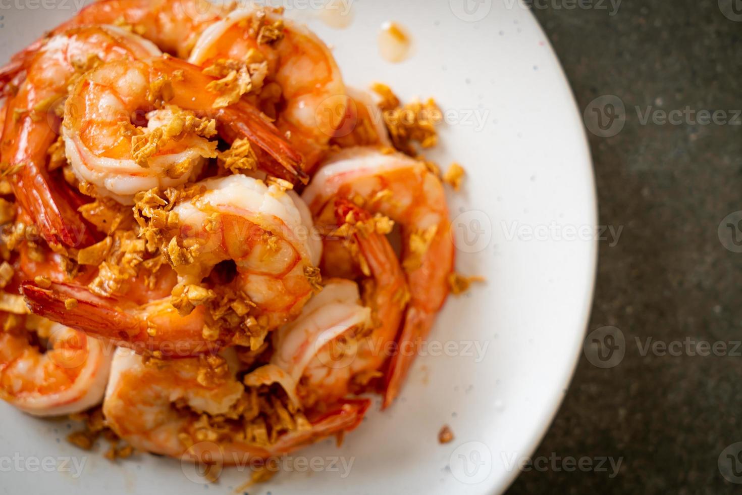 crevettes ou crevettes frites à l'ail sur une assiette blanche - style fruits de mer photo
