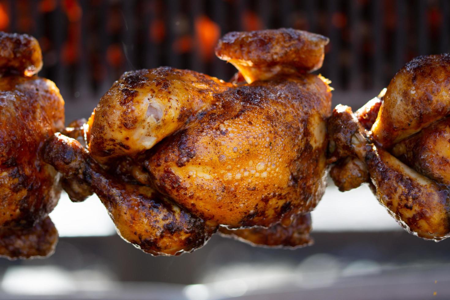 poulets rôtis à la broche grillés au feu d'un grand barbecue photo