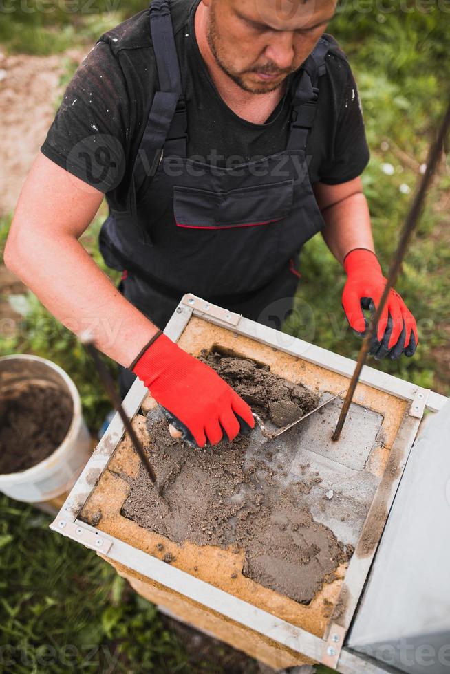 un homme construit une maison pour une famille - murs de maçonnerie - logements de banlieue photo