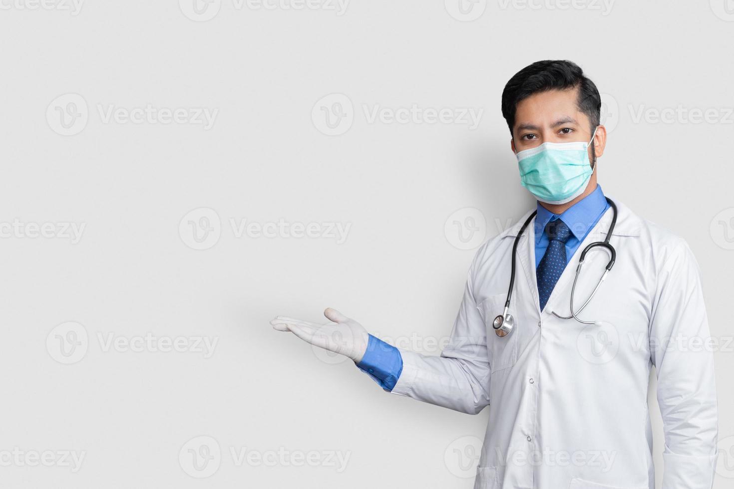 médecin en uniforme souriant tout en présentant et en pointant isolé sur fond blanc avec espace de copie photo