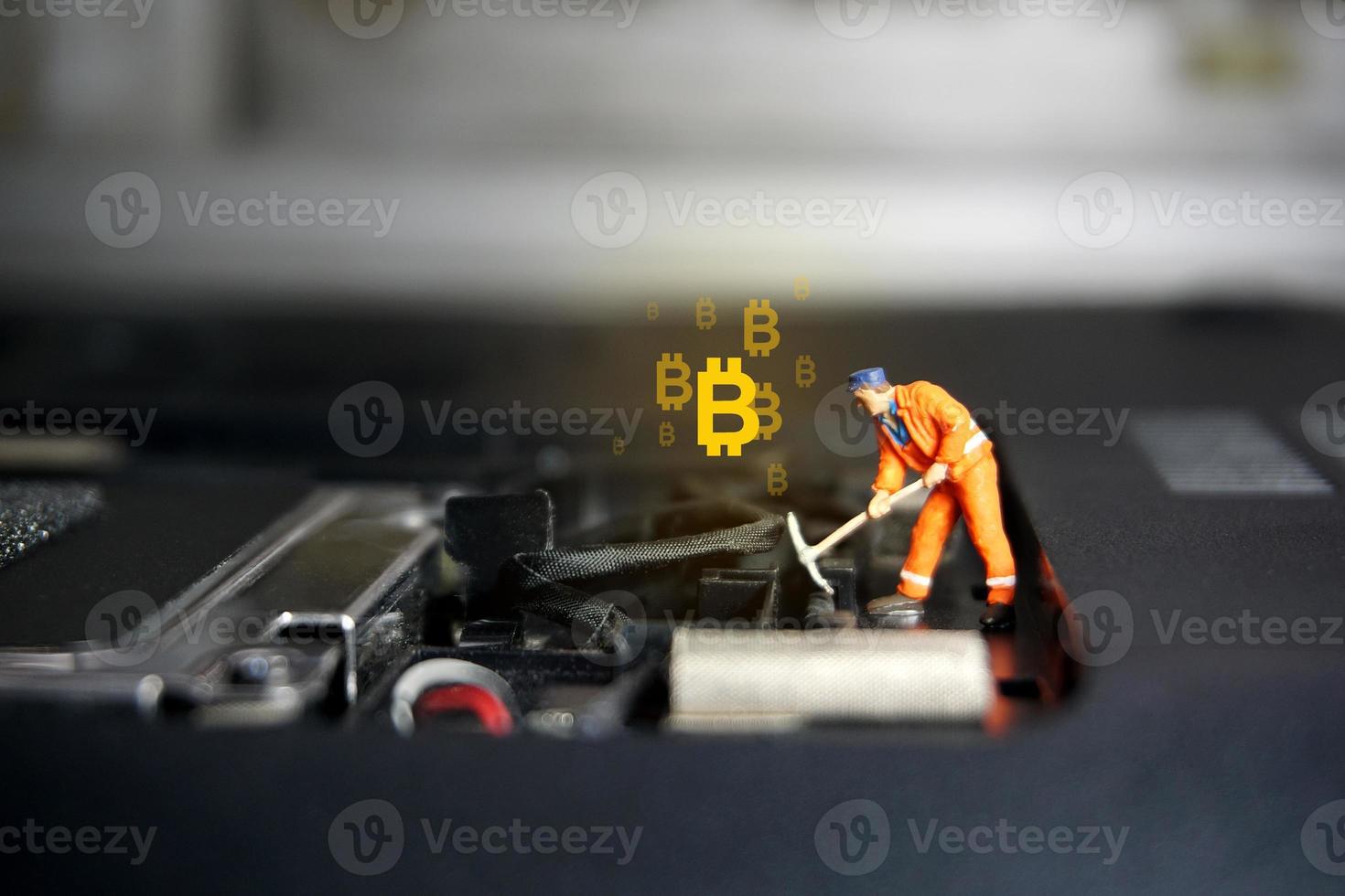 figure de travailleur technicien debout sur un ordinateur portable. concept de crypto-monnaie bitcoin. photo