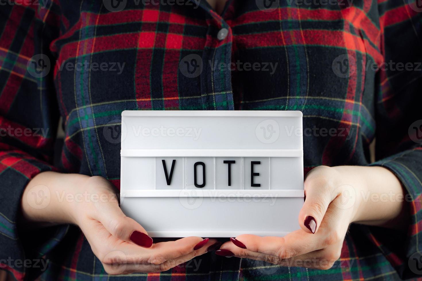 la femme tient une pancarte dans ses mains. concept de vote et d'élections en ligne. photo