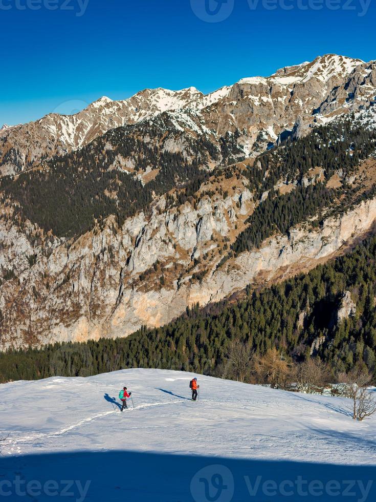 paysage de montagne avec de la neige avec deux randonneurs photo