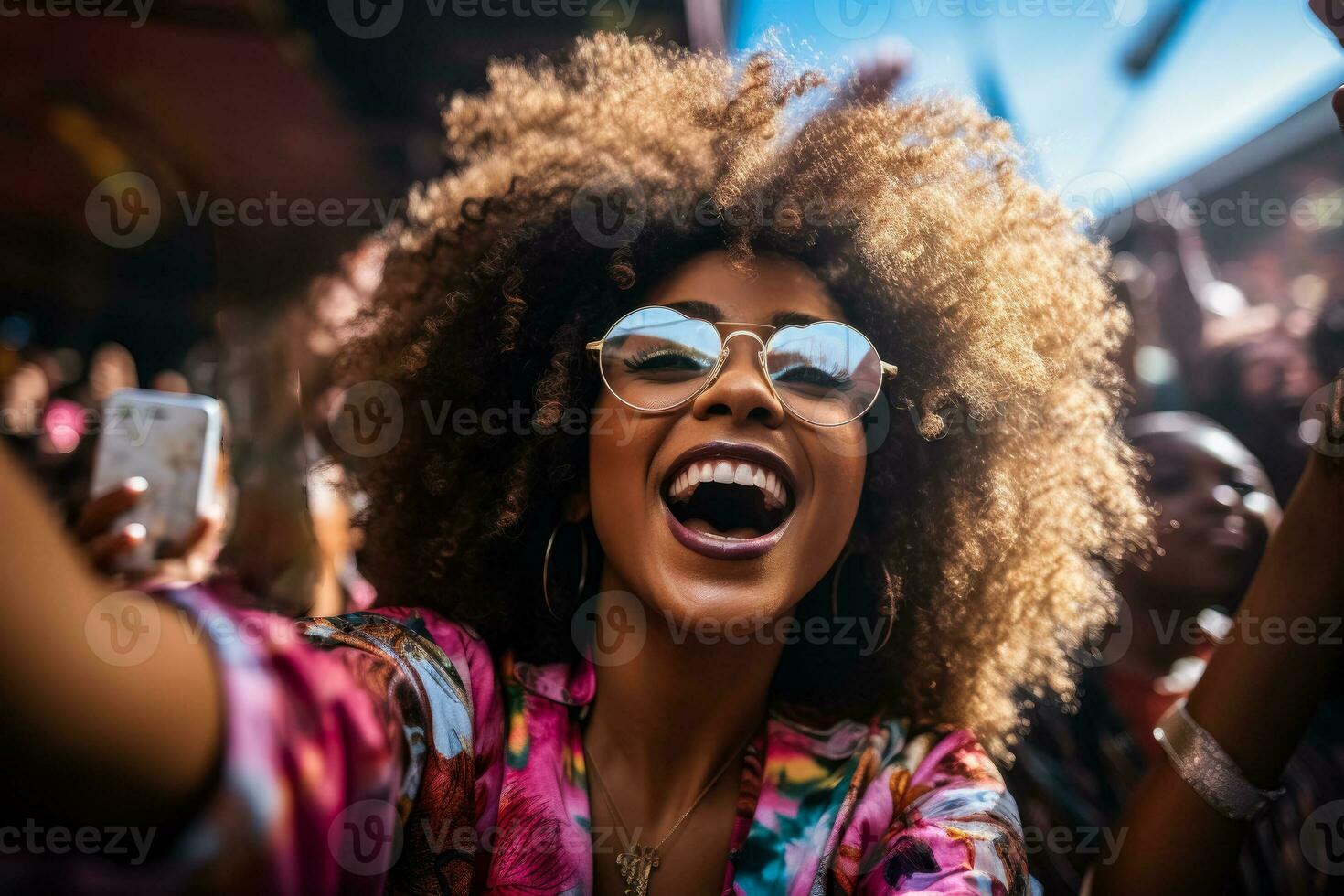 africain américain femme avec afro foule surfant Ventilateurs à concert en portant iphone dans coloré tenues et cool des lunettes de soleil photo