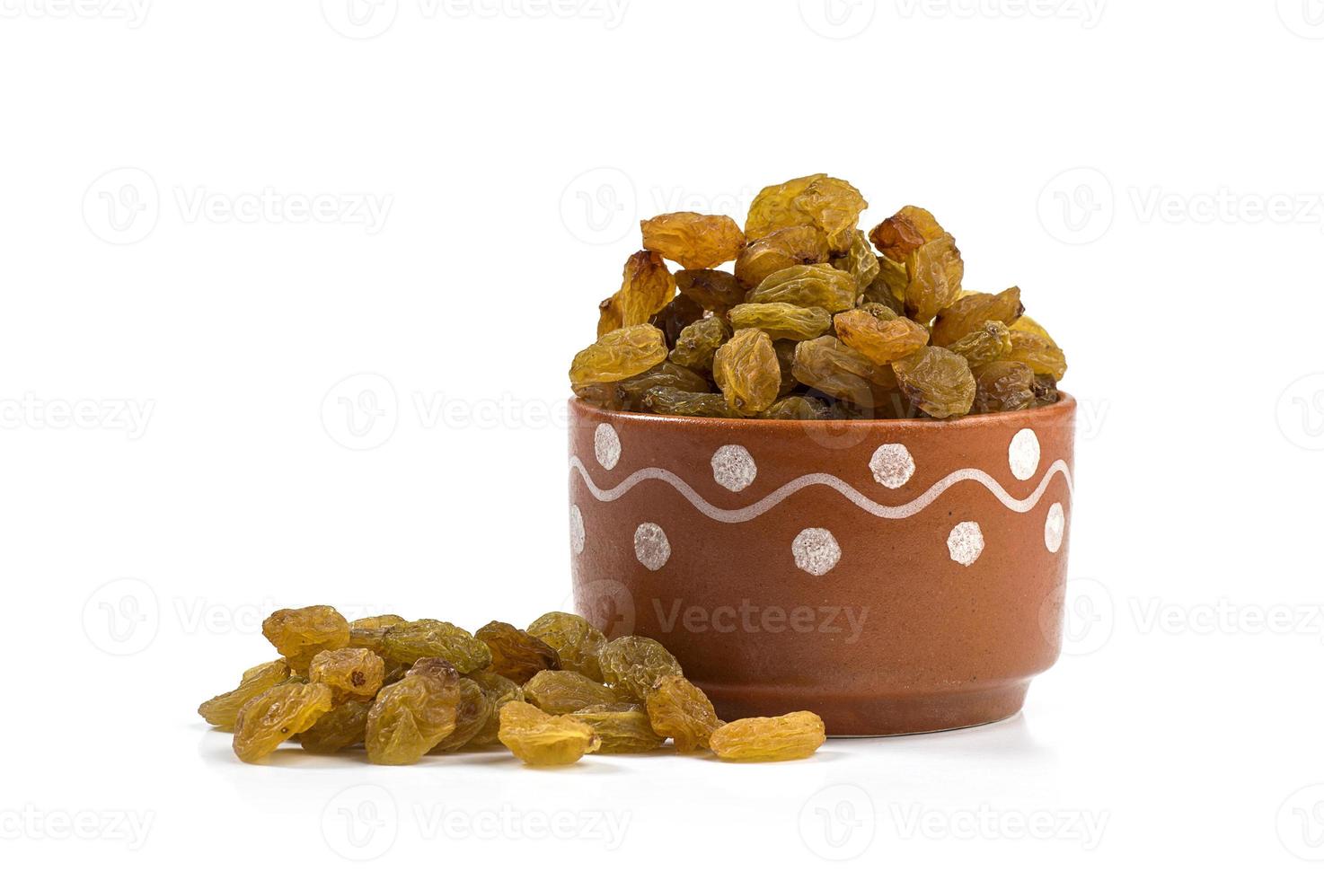 raisins secs dans un bol en argile sur fond blanc photo