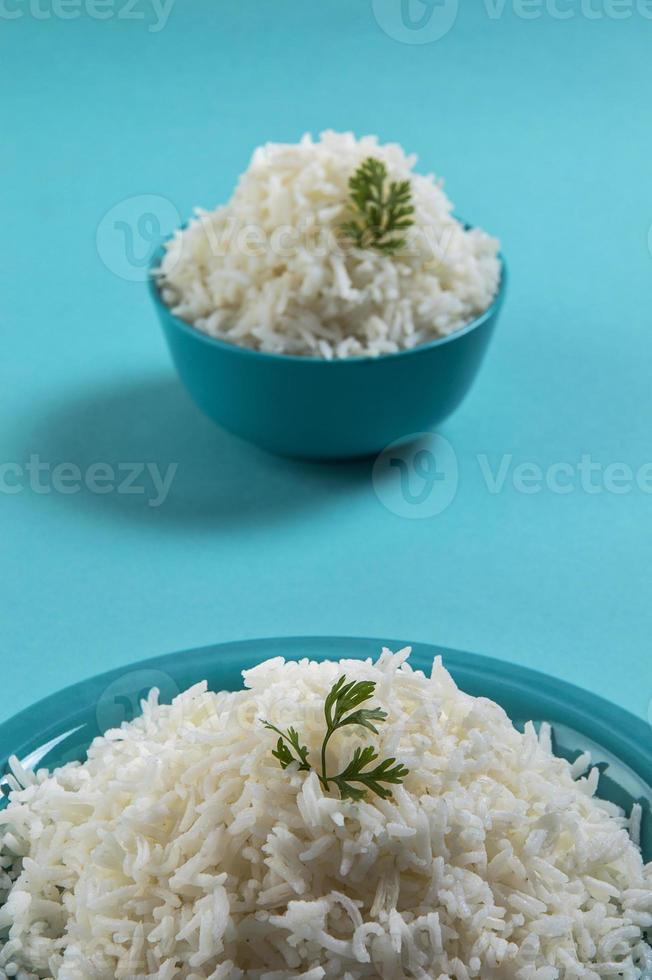 riz basmati blanc ordinaire cuit dans une assiette bleue et un bol sur fond bleu photo