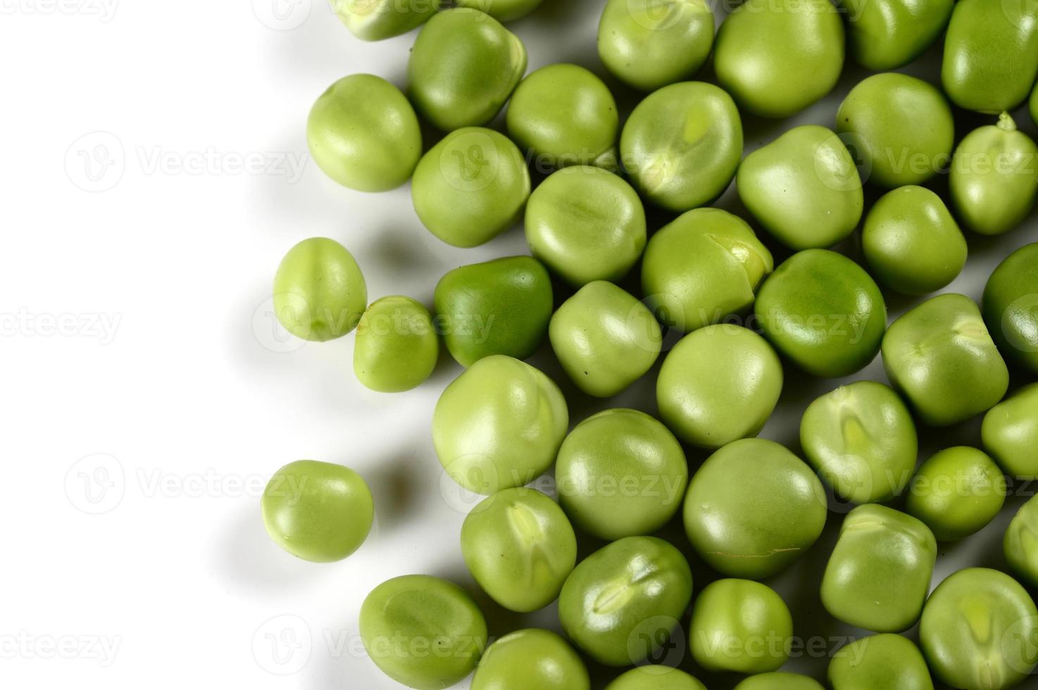 Pois verts frais en plaque blanche sur fond blanc photo