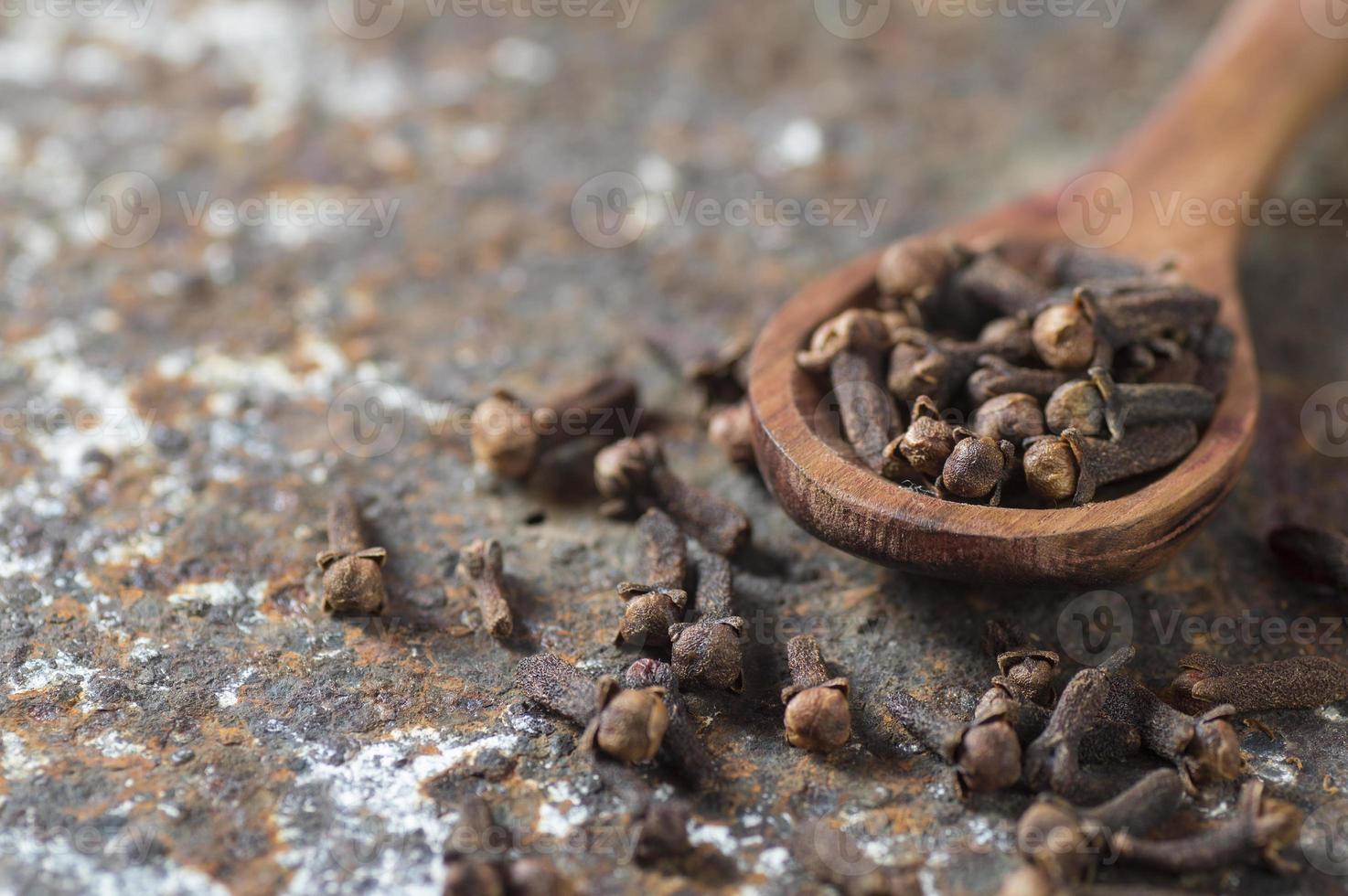 clous de girofle sur un fond texturé. épices, aliments et ingrédients de cuisine. photo