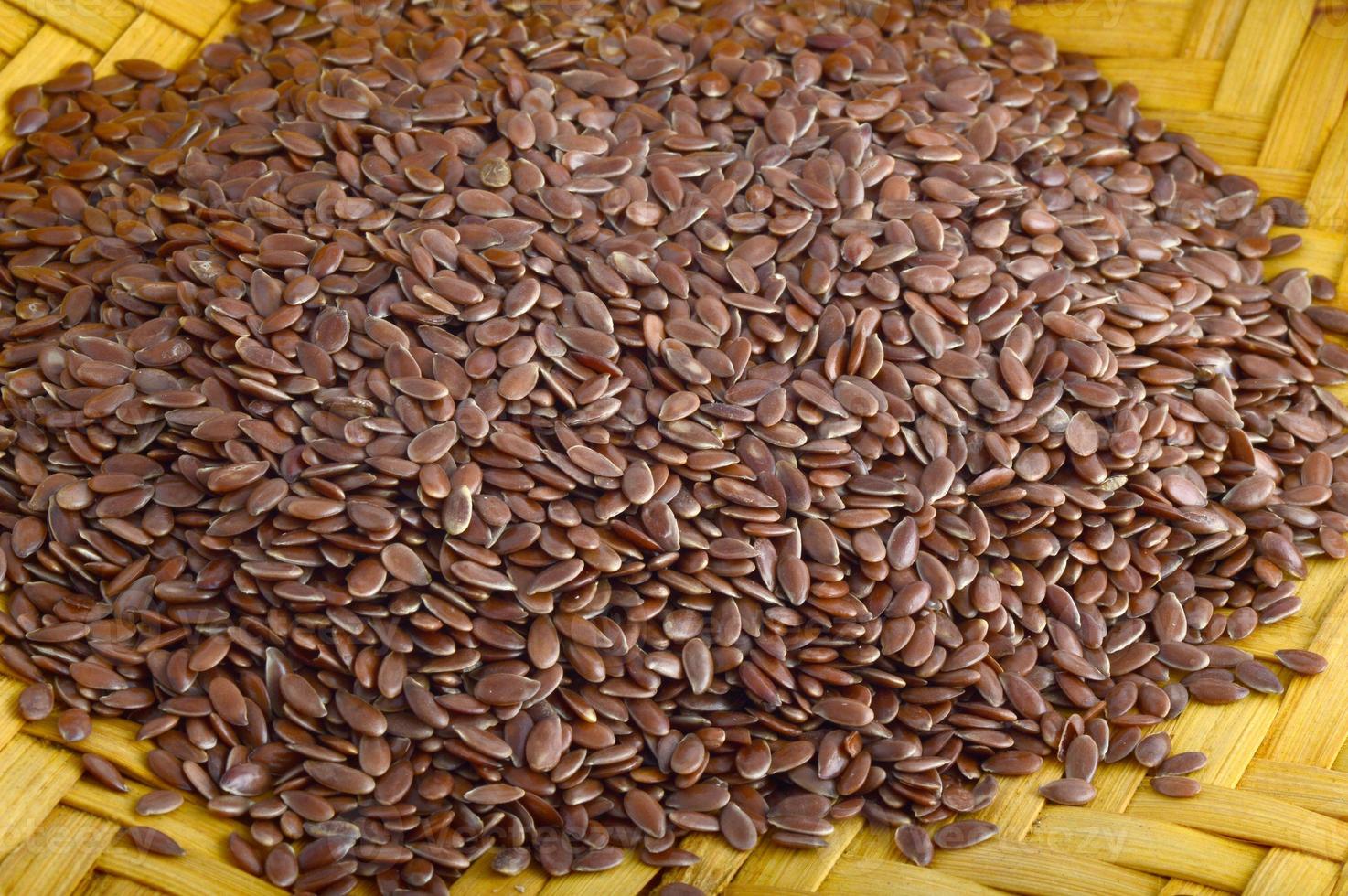 Close up de graines de lin dans un panier en bois sur fond blanc photo