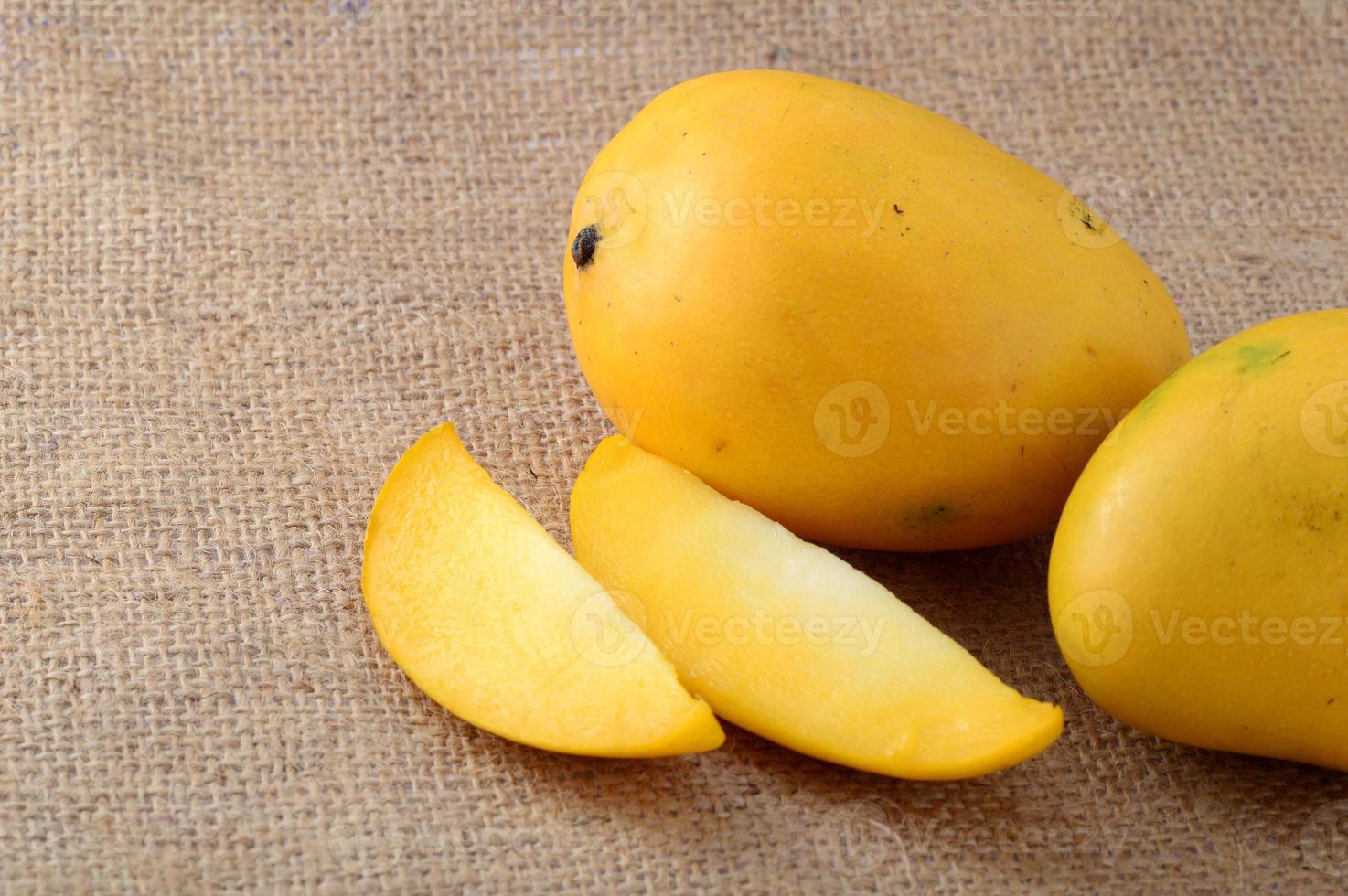 Fruit de mangue avec tranche sur fond de tissu de sac photo