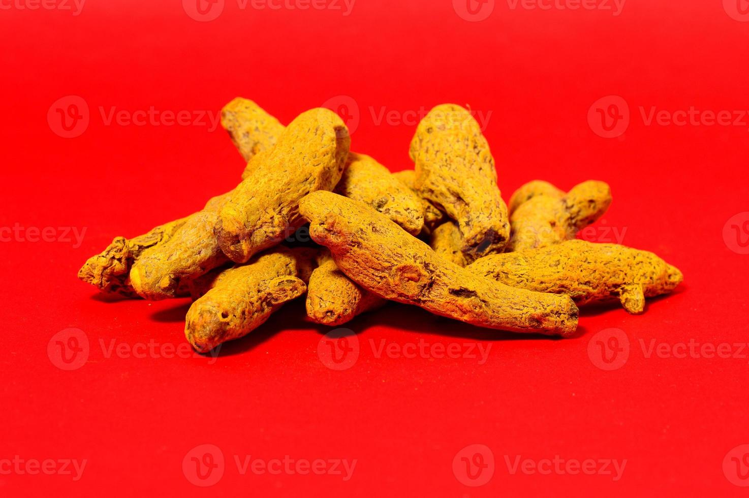 écorces de curcuma jaune sur fond rouge photo